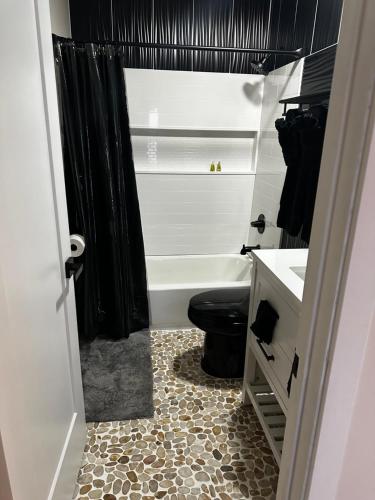 a bathroom with a black shower curtain and a toilet at The Cowboy Glamping Dome in Willcox