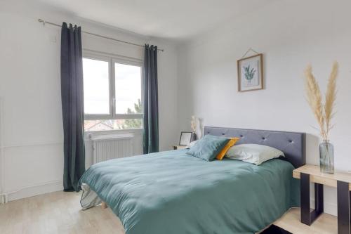 une chambre avec un lit bleu avec une fenêtre dans l'établissement *Le moderne* Paris / la Défense parking / JO 2024, à Houilles