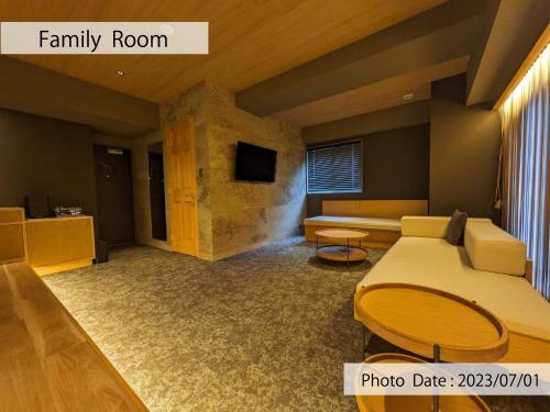 uma sala de estar com uma cama e uma televisão em HOTEL TOMOS ASAKUSA em Tóquio