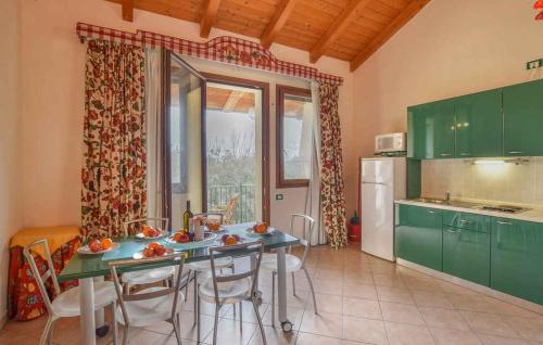 una cocina con armarios verdes y una mesa con sillas en Studio in Isola di Albarella 49973, en Caleri