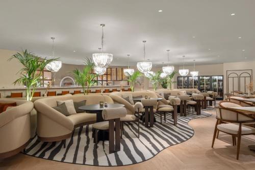 a waiting room with chairs and tables and chandeliers at Cardo Roma, Autograph Collection in Rome