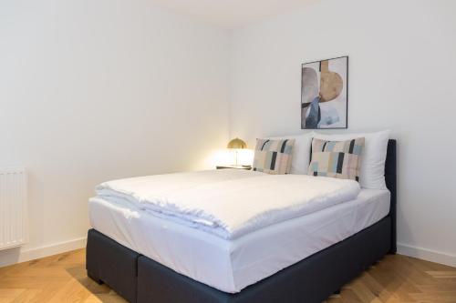 a large bed in a room with a lamp at living TIMELESS - Adler Apartments Sasbachwalden in Sasbachwalden