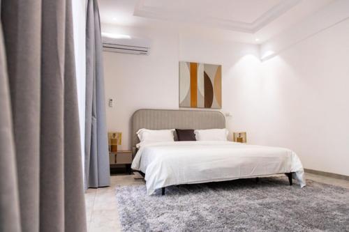 sypialnia z białym łóżkiem i dywanem w obiekcie Comfy 3 Bedroom Apartment in Ngor Almadies, Dakar w mieście Dakar