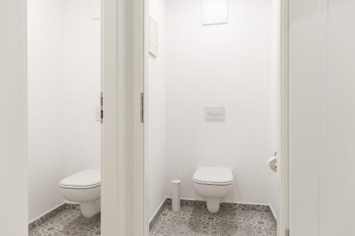 a white bathroom with two toilets and a floor at living TIMELESS - Adler Apartments Sasbachwalden in Sasbachwalden