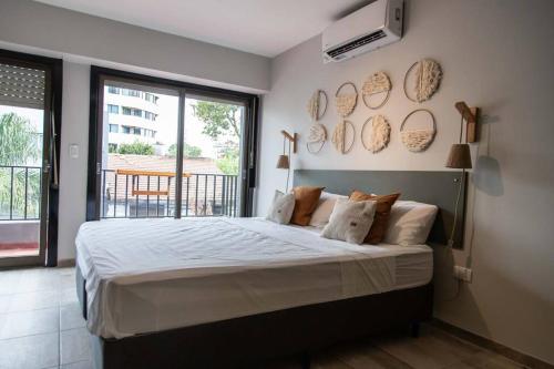 a bedroom with a large bed and a large window at Departamento del río Paraná de las Palmas in Campana