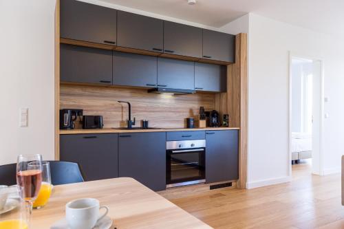a kitchen with blue cabinets and a wooden table at living TIMELESS - Adler Apartments Sasbachwalden in Sasbachwalden