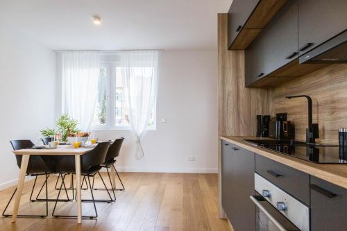 a kitchen and dining room with a table and chairs at living TIMELESS - Adler Apartments Sasbachwalden in Sasbachwalden