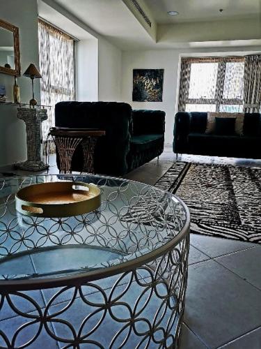 een woonkamer met een tafel en een bank bij Luxury stay in Marina in Dubai