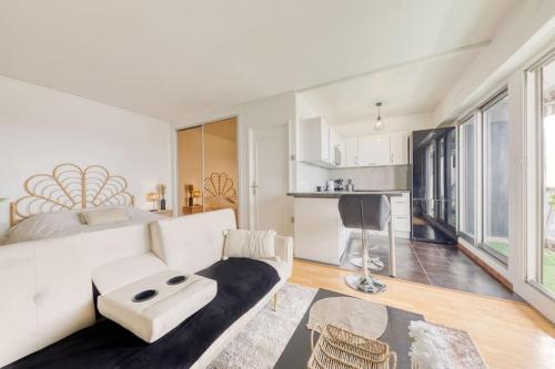 un salon avec un canapé blanc et une table dans l'établissement *Le sublime* vue sur la tour Eiffel / JO 2024, à Saint-Maurice