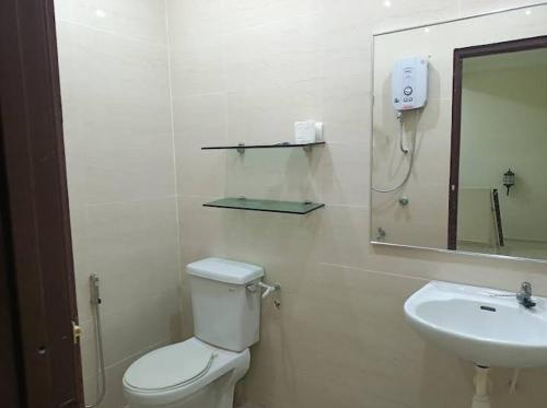 ein weißes Bad mit einem WC und einem Waschbecken in der Unterkunft Villa Senitaman Organik in Seremban