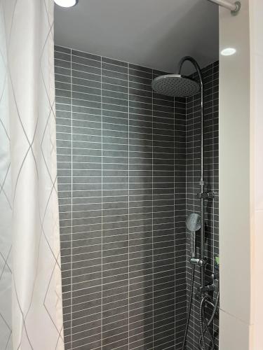 a bathroom with a shower with black tile at Torrenostra Sea Dream in Torreblanca
