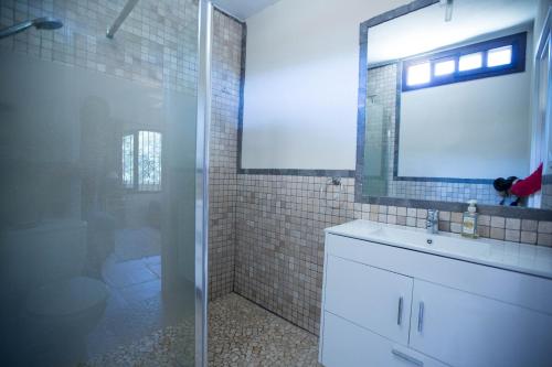 ein Bad mit einer Dusche, einem Waschbecken und einem Spiegel in der Unterkunft Villa in Marbella center in Marbella