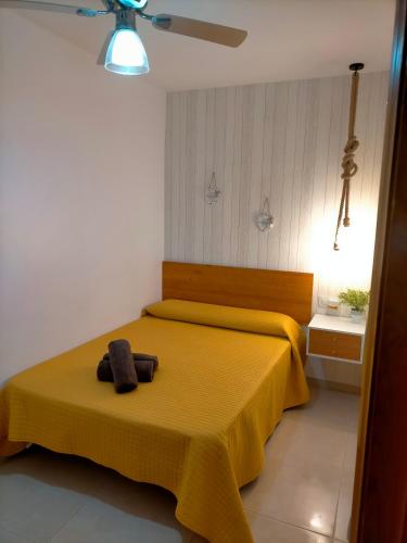 een slaapkamer met een geel bed met een handdoek erop bij Apartamento avenida de la musica in Conil de la Frontera