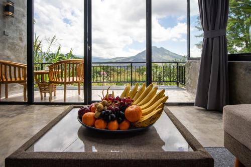 a bowl of fruit on a table in a room at Mountain Peak Kintamani in Kintamani