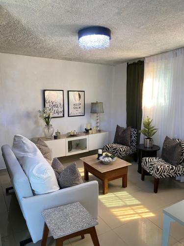 ein Wohnzimmer mit einem Sofa und einem Tisch in der Unterkunft Bleesed House in Monte Adentro