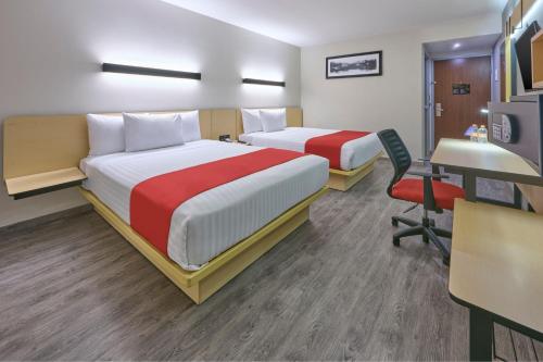 a hotel room with two beds and a desk at City Express by Marriott Ciudad de Mexico Aeropuerto in Mexico City