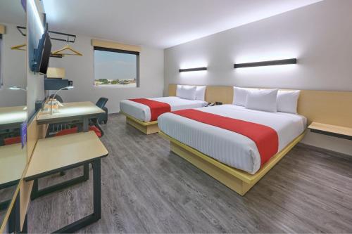 a hotel room with two beds and a desk at City Express by Marriott Ciudad de Mexico Aeropuerto in Mexico City