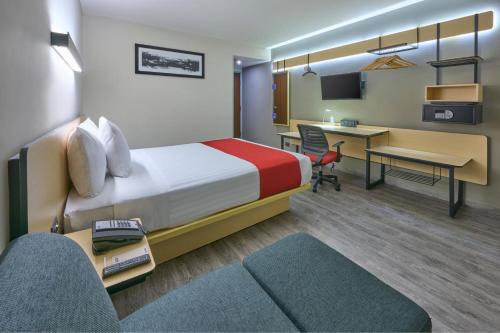 a hotel room with a bed and a desk at City Express by Marriott Ciudad de Mexico Aeropuerto in Mexico City