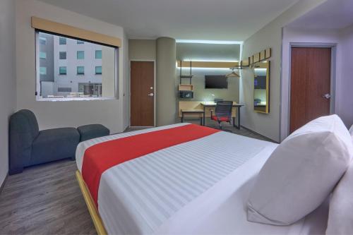 a hotel room with a large bed and a desk at City Express by Marriott Ciudad de Mexico Aeropuerto in Mexico City