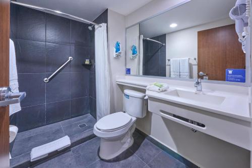 a bathroom with a toilet and a sink and a shower at City Express by Marriott Ciudad de Mexico Aeropuerto in Mexico City