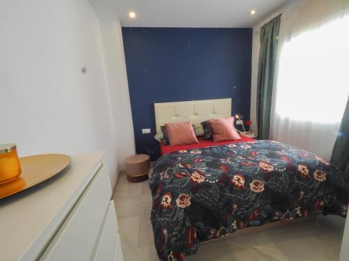 a bedroom with a bed and a blue wall at Ollerías 35 by Nagoa Homes in Málaga