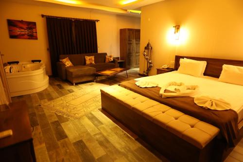 a bedroom with a bed and a bathroom with a tub at EL NAZAR STONE SUİTE in Uchisar