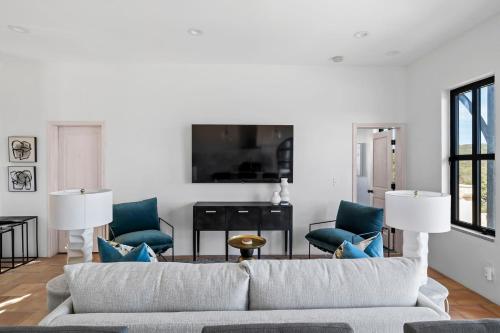 a living room with a couch and blue chairs at Las Luces in Spicewood