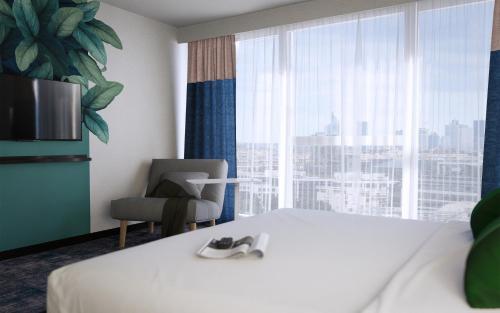 a hotel room with a bed and a chair and a window at ibis Styles Bezons Paris La Défense in Bezons
