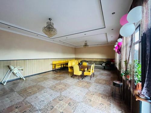 uma sala de jantar com cadeiras amarelas e uma mesa em Гостевой дом Вояж em Karakol