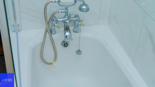 a shower in a bathroom with a shower head at 2ndHomeStays-Dudley-Suitable for Contractors and Families, Parking available for 3 Vans, Sleeps 12 in Dudley