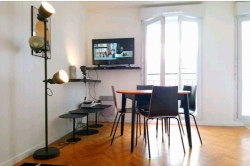 une salle à manger avec une table et des chaises dans l'établissement The Unforgetable at Canal de l'Ourcq, à Paris