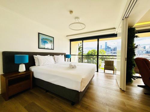 1 dormitorio con 1 cama grande y balcón en River Plaza Apartments Brisbane, en Brisbane