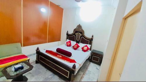 een slaapkamer met een bed met rode kussens bij Mulbnrry inn Guest house Lahore in Lahore