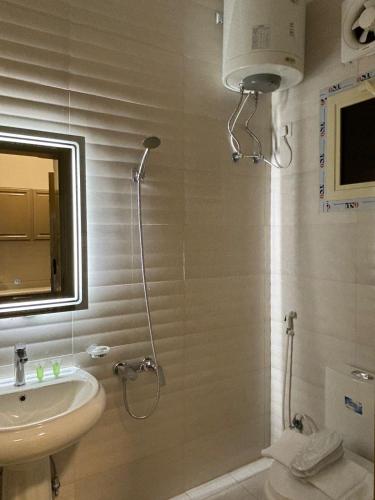 a bathroom with a shower and a sink and a mirror at فندق تلاقِ in Al Madinah