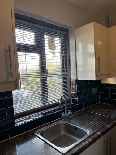 a kitchen with a sink and a window at Charlton, Greenwich Luxury Self Check-in Rooms in London