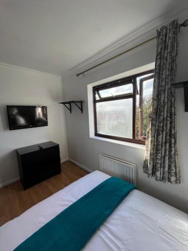 a bedroom with a bed and a window at Charlton, Greenwich Luxury Self Check-in Rooms in London