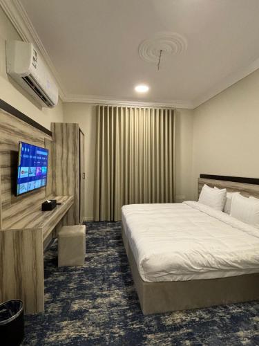 Habitación de hotel con cama y TV de pantalla plana. en فندق تلاقِ en Medina
