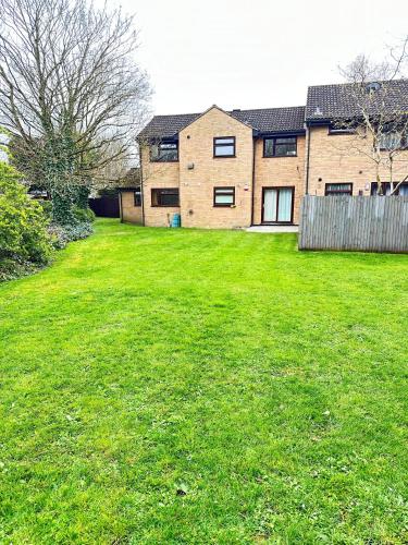 a large yard with a house in the background at 2 Bedroom Flat or Appartment near Heathrow with Garden in Uxbridge