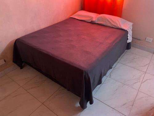 Cama en habitación con pared roja en Departamento entero en Buenos Aires en Merlo