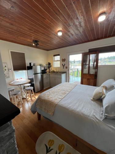 a bedroom with a large bed and a kitchen at Bridge Tender Shack with hot tub on deck in La Conner