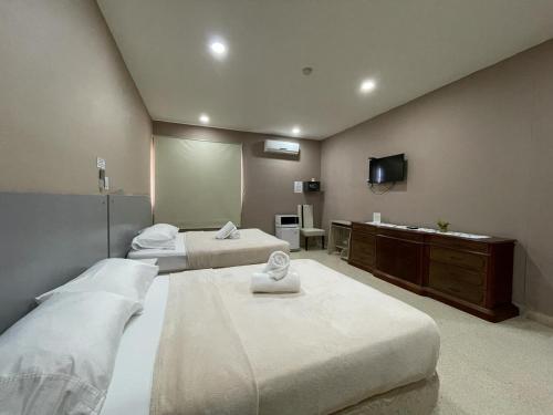 a hotel room with two beds and a television at HOSTAL IBRAIS in Panama City