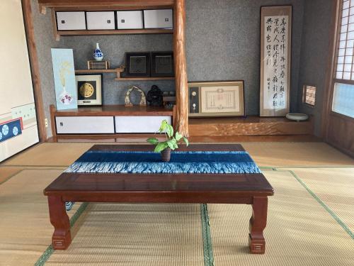 pokój ze stołem z rośliną w obiekcie 古民家のお宿ふうす w mieście Amami