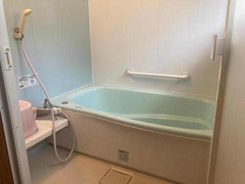 a bath tub in a bathroom with a sink at 古民家のお宿ふうす in Amami