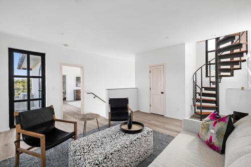 a living room with a couch and a spiral staircase at Las Luces in Spicewood