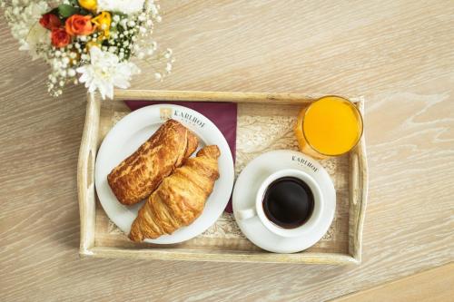 a tray with a plate of croissants and a cup of coffee at Karlhof in Sebeş