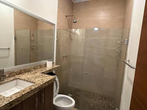 y baño con ducha, aseo y lavamanos. en Casa hermosa y acogedora en condominio privado, en Puerto Vallarta