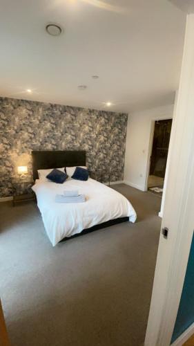 a bedroom with a white bed and a stone wall at 310 Arden Gate in Birmingham