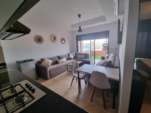 a living room with a couch and a table at Luxueux appartement Golf City Rez-de-Jardin et Piscine in Marrakesh