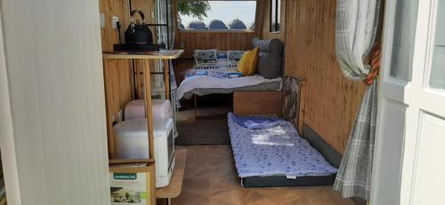 a small room with two beds and a window at Trailor Escape GLAMPING POD - our converted horse box at Nelson Park Riding Centre - Birchington, Margte, Thanet, Ramsgate, Broadstairs, Sandwich, Herne Bay in Birchington