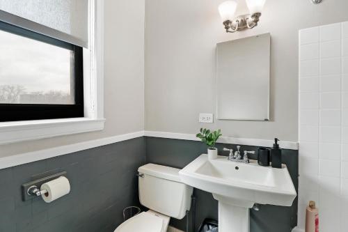 y baño con aseo blanco y lavamanos. en Enchanting 1BR Urban Retreat in Hyde Park - Windermere 401, en Chicago